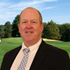 NJSGA Executive Director, Kevin Purcell, in front of lush green fairway on a sunny day.