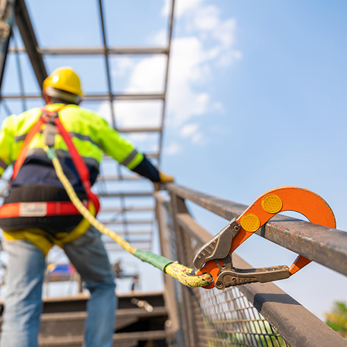 A construction worker working at height, Construction workers are working on steel roof trusses with Fall arrestor device for worker with hooks for safety body harness on the construction site. 