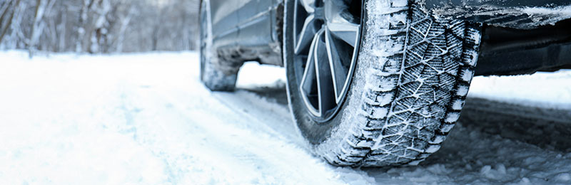 Winter Car Tire on Snowy Road