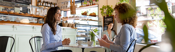Women talking in a casual job interview at a cafe - small business concepts.