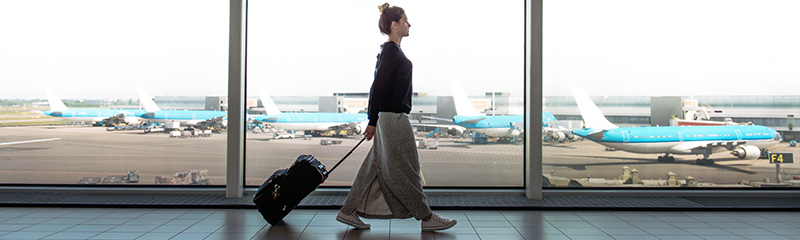 Woman with suitcase is going to board on the next flight.