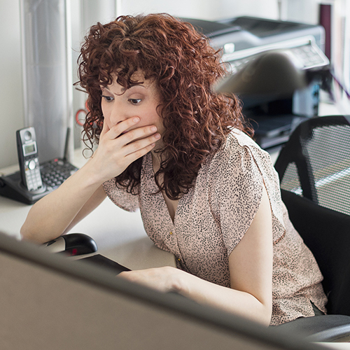 Surprised Hispanic businesswoman working in office.