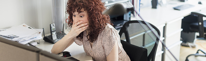 Surprised Hispanic businesswoman working in office.