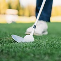 Detail of a golfer just before the swing. Focus on the golf club and ball.
