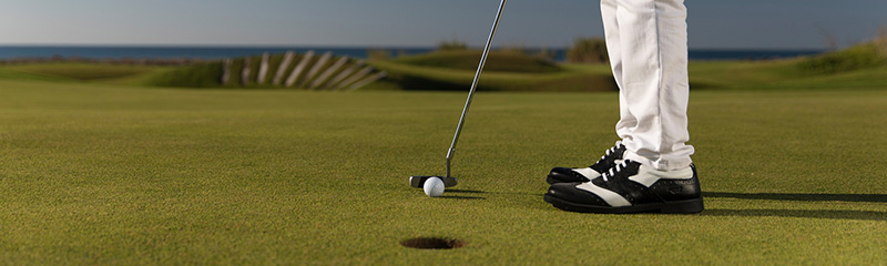Golfer teeing off the ball - Closeup detail photo while player ready for putt.