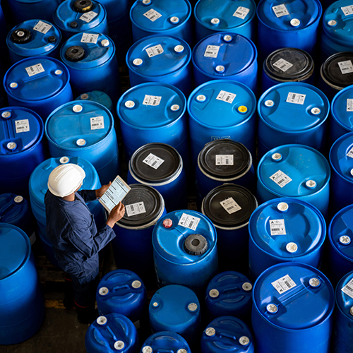 Blue-collar worker doing an inventory while working at a chemical plant.