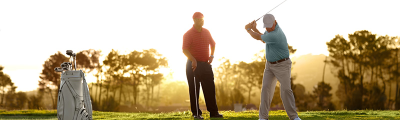 Male golfer instructing fellow golfer.