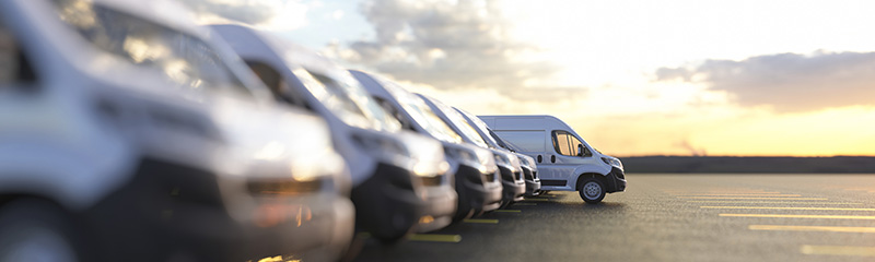 Generic row of new vans in a parking bay ready for purchase.